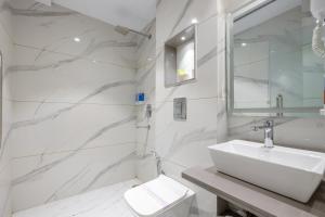a white bathroom with a sink and a toilet at The Arjun - Newly Built Hotel Just 3 Mins from Metro and Railway Station in New Delhi +63 photos