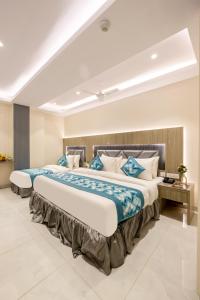 a bedroom with a large bed with blue and white pillows at The Arjun - Newly Built Hotel Just 3 Mins from Metro and Railway Station in New Delhi