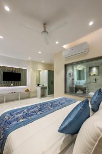 a large bedroom with a large bed with blue pillows at The Arjun - Newly Built Hotel Just 3 Mins from Metro and Railway Station in New Delhi