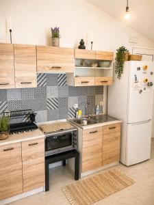 a kitchen with wooden cabinets and a white refrigerator at Panorama View in Kalamata