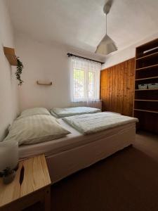 a bedroom with a large bed and a window at Kemp Oparno, bezvakempy in Malé Žernoseky