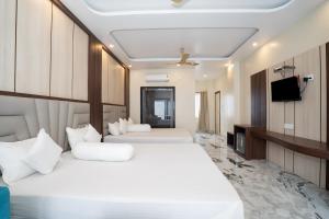 a hotel room with two beds and a television at Coral Beach Resort Mandarmoni in Mandarmoni