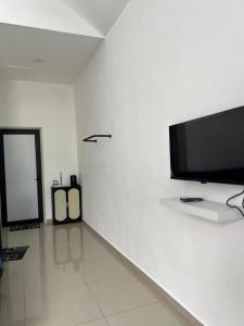 a white room with a flat screen tv on a wall at Gopeng Tiny House CUCHU in Gopeng