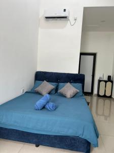 a bed with a blue comforter and pillows at Gopeng Tiny House CUCHU in Gopeng