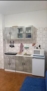 a kitchen with stainless steel cabinets and a microwave at Grazioso bilocale in Giusvalla