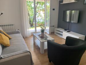 a living room with a couch and a table at Delux apartment Dora with a private parking in Rijeka