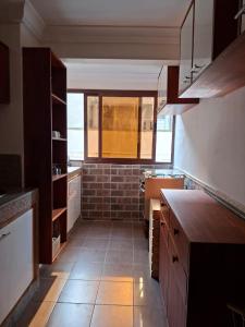 a kitchen with a sink and a brick wall at Monica Place in Abidjan