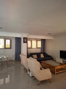 a living room with a couch and a table and chairs at Monica Place in Abidjan +2 photos