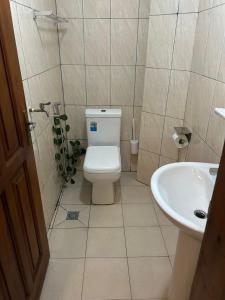 a bathroom with a toilet and a sink at Appartement cozy Bonamoussadi, WIFI & Goupe électrogène in Douala