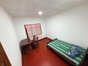 a room with a bed and a table in it at Hiker's Hub in Maskeliya