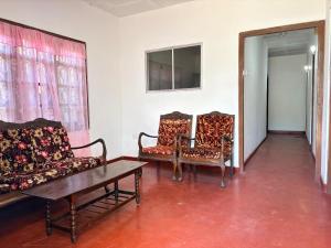a living room with two chairs and a table at Hiker's Hub in Maskeliya