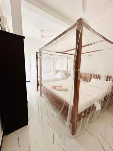 a bedroom with a bed covered in plastic at Surf Bay Hotel in Arugam Bay