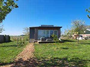 a tiny house with a window in a field at Tiny house het Polderhuisje in Streefkerk