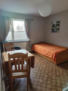 a bedroom with a bed and a table and chairs at Bettan in Bruzaholm