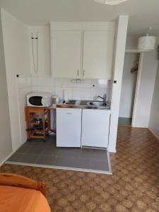 a small kitchen with white cabinets and a sink at Bettan in Bruzaholm