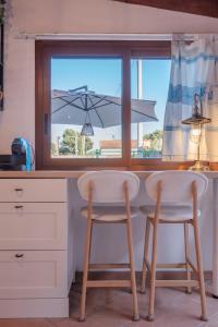 a kitchen with a table and two chairs in front of a window at Le Gioie di Laura in Su Forti +13 photos