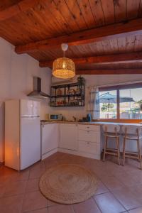 a kitchen with a white refrigerator and a table at Le Gioie di Laura in Su Forti