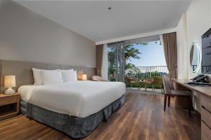 a hotel room with a bed and a large window at Flamingo Cát Bà Sea Residence , Sky Villa Premier Ocean View King Bed in Hai Phong +21 photos