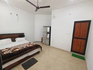 a bedroom with a bed and a ceiling fan at Anmol Hotel And Restaurant in Chandausi