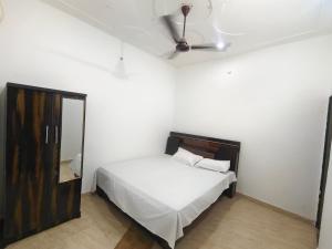 a bedroom with a white bed and a mirror at Anmol Hotel And Restaurant in Chandausi +3 photos