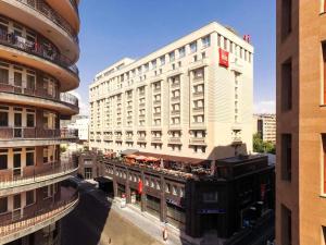 a tall white building with a red sign on it at ibis Yerevan Center in Yerevan