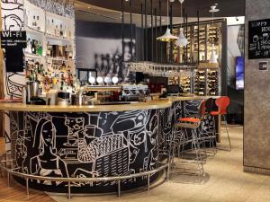 a bar with a black and white painting on it at ibis Yerevan Center in Yerevan