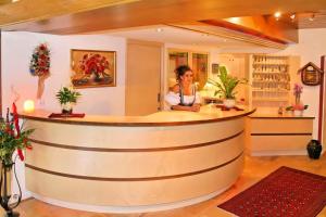 a woman standing at a bar in a restaurant at Hotel Kajetansbrücke in Pfunds