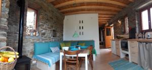 a kitchen and living room with a blue couch and a table at Tinos Ecolodge in Tinos