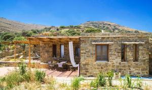 a stone house in the middle of a mountain at Tinos Ecolodge in Tinos