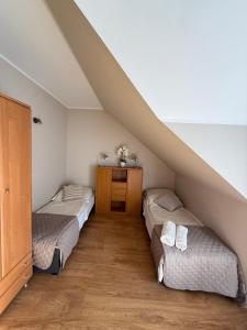 a attic bedroom with two beds and a staircase at Dom nad jeziorem Mazury pomost segment 2 in Giżycko