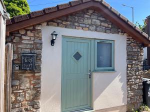 a garage with a green door and a window at Mini Treacle Cottage in Dundry