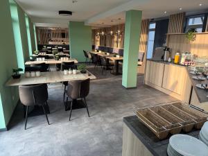 a restaurant with wooden tables and chairs and green walls at AS-Hotel NOM in Northeim