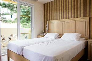 a large bed in a bedroom with a large window at Kastalia Village ,Saint Nikolas resort in Kolymvari +31 photos