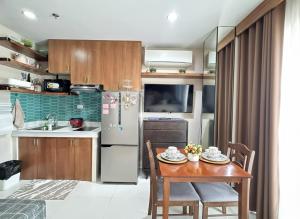 a kitchen with a table and a stainless steel refrigerator at Residencias Lim - Cityscape Residences in Bacolod