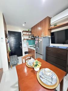 a kitchen with a wooden table with two plates on it at Residencias Lim - Cityscape Residences in Bacolod