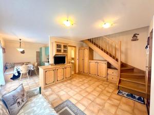 a living room with a staircase and a dining room at Cèsa Aurora in Canazei