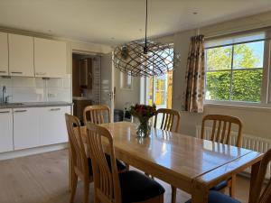 a kitchen and dining room with a wooden table and chairs at Pinkeltje in Aagtekerke