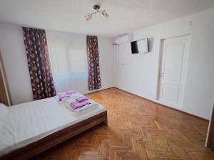 a small bedroom with a bed and a door at Casă de vacanță Danube in Moldova Nouă