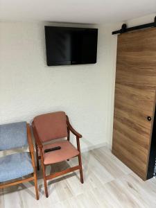 a room with a chair and a television on a wall at CHEPIBAROS Turismo in San Pedro