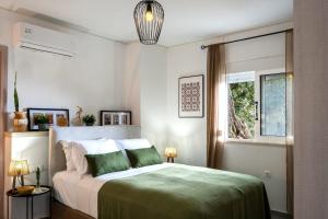 a bedroom with a bed with green sheets and a window at Vrachos Nature Lodges PRINOS 3, Private pool in Agia Galini +36 photos