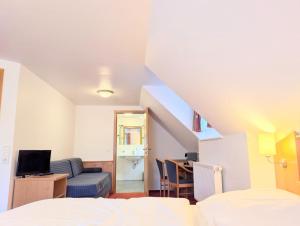 a bedroom with a bed and a couch and a desk at Turmhütte in Lauterbach