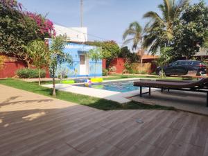 a blue house with a pool in a yard at Cases conviviales et chaleureuses in Sali Tapé