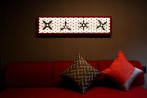 a red couch with pillows sitting under a window at Kamenoi Hotel Aso Park Resort in Aso +139 photos