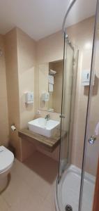 a bathroom with a sink and a shower and a toilet at Hostal Restaurante Carolina in Pedrosillo el Ralo +53 photos