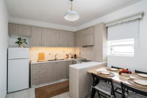 a kitchen with wooden cabinets and a table with chairs at Mesogitonia House in Zekros