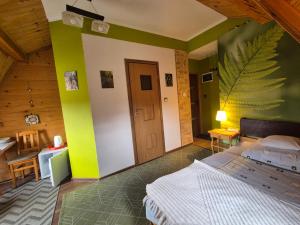 a bedroom with a white bed and a green wall at Willa Helena in Cisna