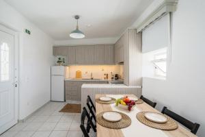 a kitchen with a wooden table and chairs and a kitchen with a counter at Mesogitonia House in Zekros