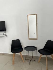 three chairs and a table in front of a mirror at Gopeng Tiny House CUCHU in Gopeng