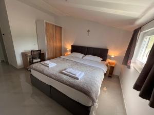 a bedroom with a bed with two towels on it at ROOMS Međugorje in Međugorje