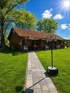 a log house with a pathway leading to it at Cicha Dolina in Wydminy